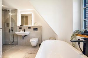 une salle de bains blanche avec toilettes et lavabo dans l'établissement Sky & Sand, à Westerland 16 autres photos