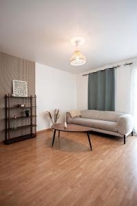 un salon avec un canapé et une table dans l'établissement 10min de Disney Duplex 2ch avec Parking & Balcon, à Bailly-Romainvilliers