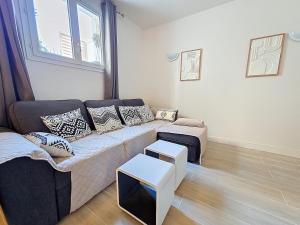 a living room with a couch and a table at 2 Pièces cosy proche Metro in Asnières-sur-Seine