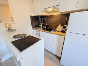 a kitchen with white appliances and a white refrigerator at 2 Pièces cosy proche Metro in Asnières-sur-Seine