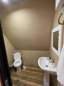 a small bathroom with a toilet and a sink at Typebi in K'obulet'i