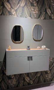 a bathroom with a white dresser and two mirrors at Metropolitan am Schloßpark in Paderborn +41 photos