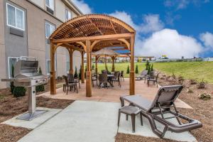 a pavilion with chairs and a grill and a table and chairs at Sleep Inn & Suites Jasper I-22 in Jasper