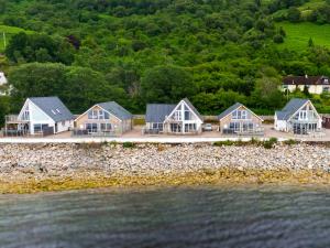 Beach Houses with Hot Tubs في غلينكو: صف من البيوت على شاطئ الماء