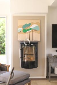 a fireplace in a living room with a painting of trees at COC - Villa Parenthèse in Tardinghen