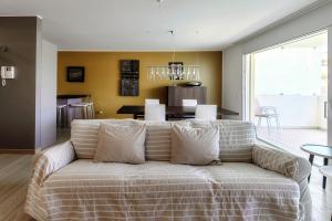 a living room with a couch and a dining room at Sandi Luxury Apartment by Quokka 360 - modern flat in Lugano in Paradiso