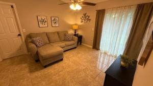 a living room with a couch and a window at M13 Large Master Room with Private Bathroom & Smart TV in Orlando +2 photos