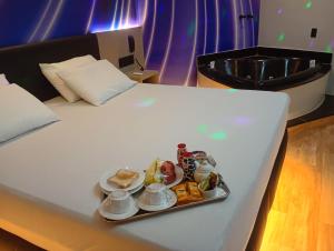 a tray of food sitting on top of a bed at STILLUS MOTEL - Suítes Privativas Confortáveis em Imperatriz in Imperatriz