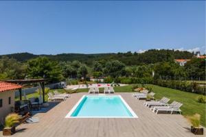 a swimming pool with lounge chairs and a resort at Arteon villas in Akti Salonikiou
