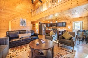ein Wohnzimmer mit Ledersofas und eine Küche in der Unterkunft Smoky Ridge Retreat By Avada Properties in Sevierville