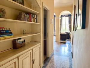 Una habitación con un pasillo con estanterías y una cocina. en LISOLA Appartamento con vista lago, en Orta San Giulio