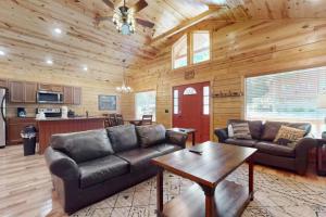 a living room with leather couches and a table at Southern Comfort Cabin By Avada Properties in Gatlinburg
