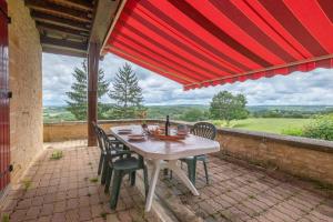 Una mesa y sillas en un patio con vista. en Résidence musicale de Panissal, en Montignac