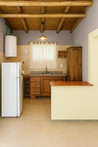 una cucina con frigorifero bianco e armadietti in legno di Cabañas Zelat a San Rafael