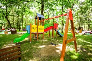 River Park Zator SPA RESORT في زاتور: ملعب مزود بزحليقة في حديقة