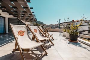 a row of deck chairs sitting on a roof at Apartments Zovko in Neum