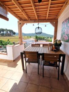 a wooden table and chairs on a patio with a view at Villa de Gracia Casa 2 in Tordera