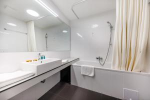 a white bathroom with a sink and a shower at Akademis Academia in Dubrovnik