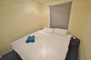 a bed with a pair of blue shoes on it at Kalbarri Garden Apartment 11 - Kalbarri, WA in Kalbarri +4 photos