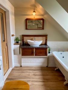 a bathroom with a sink and a bath tub at Highland Rooms - Room Only No Breakfast in Ullapool