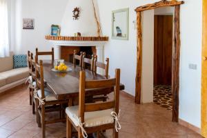 een eetkamer met een tafel en stoelen en een open haard bij Casa Ginepro in Olbia