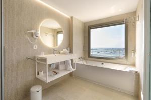 łazienka z wanną, umywalką i lustrem w obiekcie Bellamar Hotel Beach & Spa w mieście San Antonio