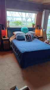 a bedroom with a bed with blue sheets and a window at Blū House in Williamsburg