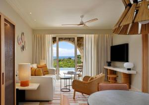 a living room with a couch and a tv at The Westin Resort, Costa Navarino in Romanu