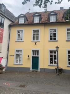 a yellow house with a green door at Altes Forstamt in Xanten