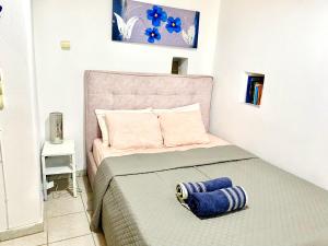 a small bedroom with a bed with a pink headboard at Chora Suite in Mikonos