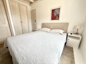 a bedroom with a white bed and a night stand at Betty'appartment Mykonos in Panormos Mykonos