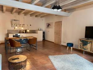 a living room with a table and chairs and a kitchen at Ferienwohnungen Annweiler am Trifels in Annweiler am Trifels