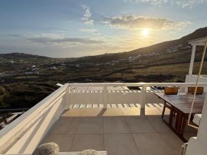a balcony with a table and the sun in the sky at Betty'appartment Mykonos in Panormos Mykonos