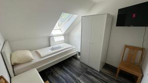 a small white room with a window and a bed at Pension Smart Living Suites in Nuremberg