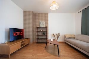 un salon avec un canapé et une télévision dans l'établissement 10min de Disney Duplex 2ch avec Parking & Balcon, à Bailly-Romainvilliers 20 autres photos