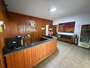 a lobby of a salon with a reception counter at Hotel Santa Catarina in Três Lagoas