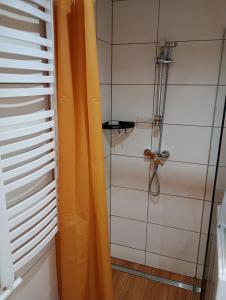 a shower with an orange curtain in a bathroom at Domek pod Lipą in Nienaszów +20 photos