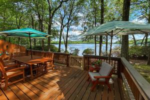 a wooden deck with a table and two umbrellas at Big Boulder Lake Townhome in Lake Harmony