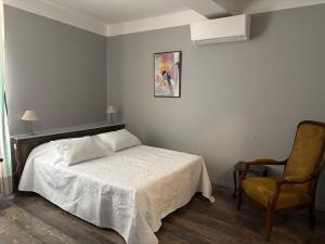 une chambre avec un lit et une chaise dans l'établissement El Castell Embruixat, à Saint-Hippolyte