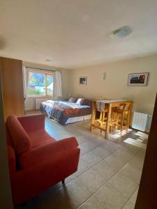 Un dormitorio con una cama, un sofá y una mesa. en Apart Roca - UF 103, en San Martín de los Andes