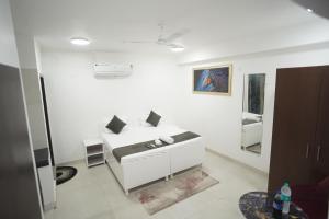 a white room with a bed and a mirror at Hotel Airport Stay in New Delhi