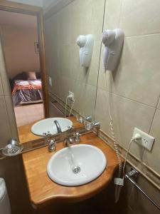 un baño con lavabo y espejo en Apart Roca - UF 103, en San Martín de los Andes