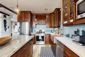 una cucina con armadietti in legno ed elettrodomestici in acciaio inossidabile di Mermaid Manor a Fort Bragg Altre 17 foto