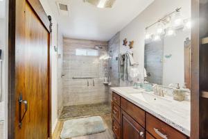 un bagno con doccia, lavandino e specchio di Mermaid Manor a Fort Bragg Altre 18 foto