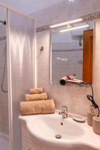 a bathroom with a sink and a mirror and towels at Book & Art Holiday House in Lido di Ostia