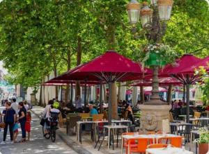 a group of people sitting at tables and umbrellas at Chalet Le Lagon in Cazilhac
