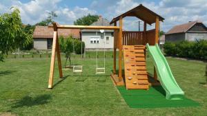 a playground with a slide and a swing at Harmónia Vendégház in Poroszló