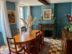 a dining room with a wooden table and a fireplace at The Artist's House Limoux in Limoux