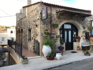 帕诺尔莫斯雷斯蒙伊蒂利酒店的石头建筑,前面有盆植物