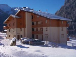ein großes Gebäude mit Autos im Schnee in der Unterkunft Appartement lumineux avec balcon et parking, 6 pers. - FR-1-198-241 in Châtel